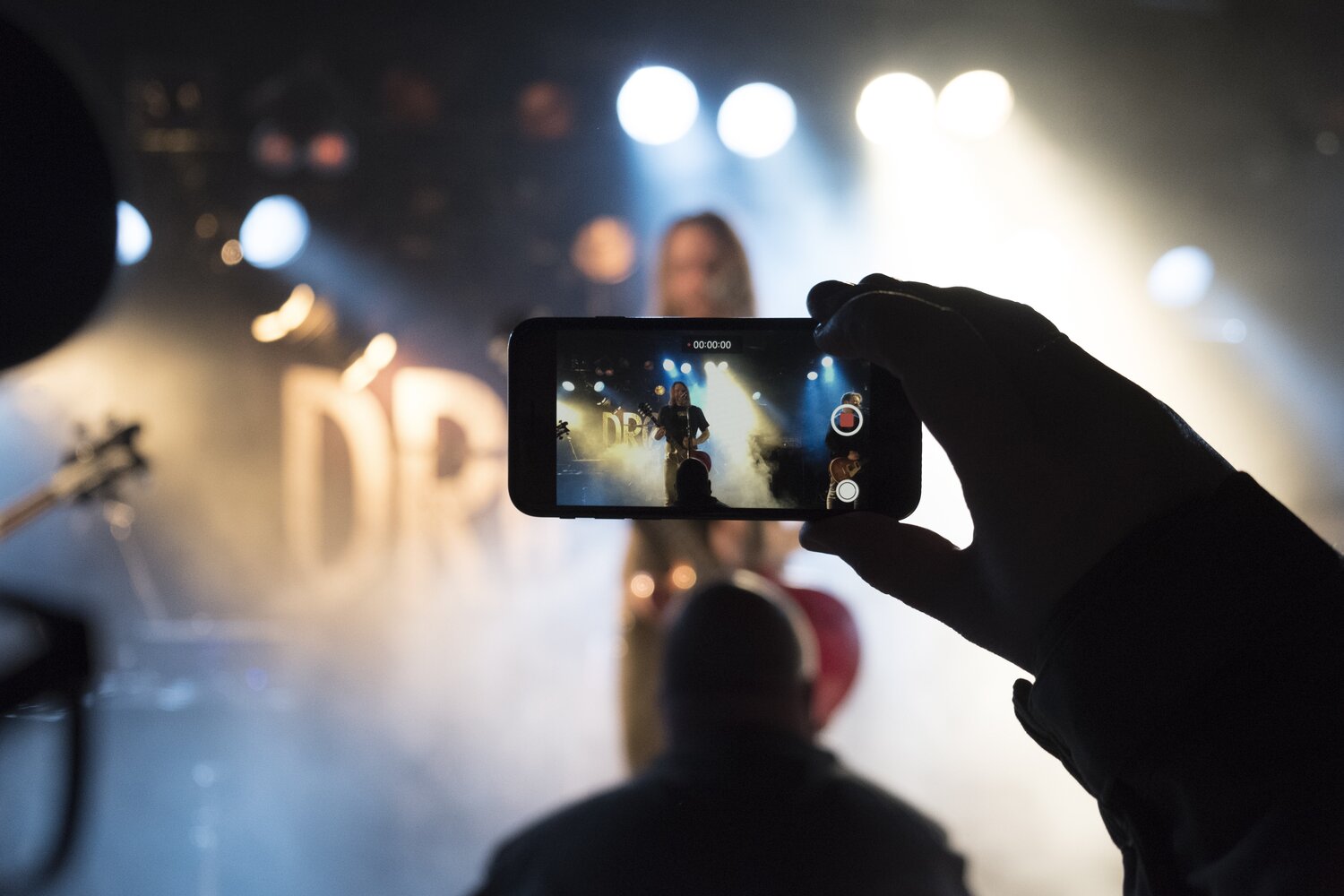 Une personne prenant en vidéo la prestation d'artistes et performers lors d'un événement professionnel avec l'agence Kap West Events.