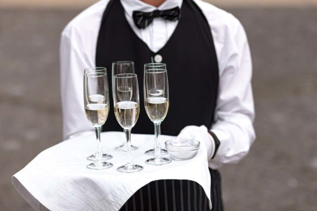 Un serveur servant le champagne, une prestation traiteur lors d'un événement professionnel avec l'agence Kap West Events.