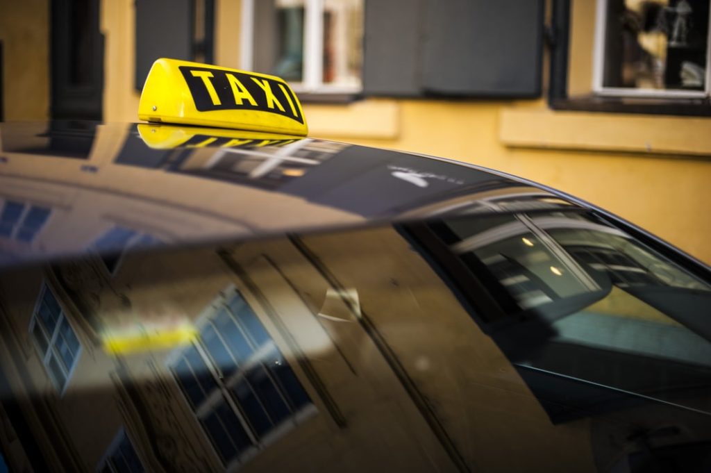 Une voiture de taxi transportant des personnes pour un événement professionnel, une prestation de l'agence Kap West Events.