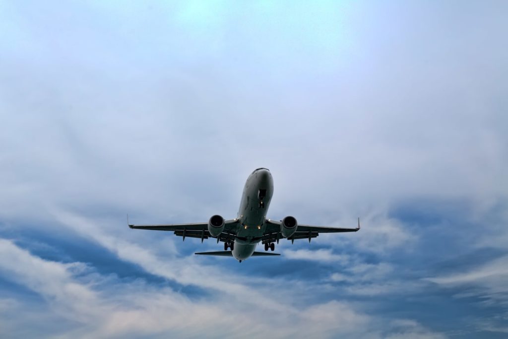 Un avion en plein vol dans le ciel transportant des passagers pour un événement professionnel, une prestation de l'agence Kap West Events.